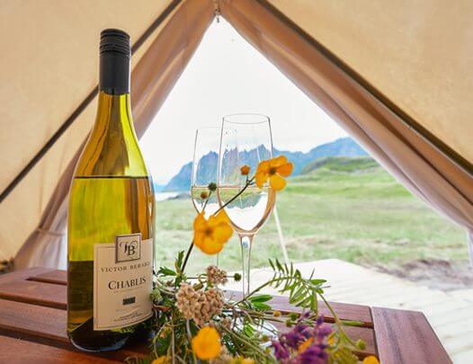 Wine and flowers on a table in a tent