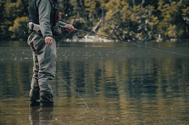 A fisherman fly fishing in a lake