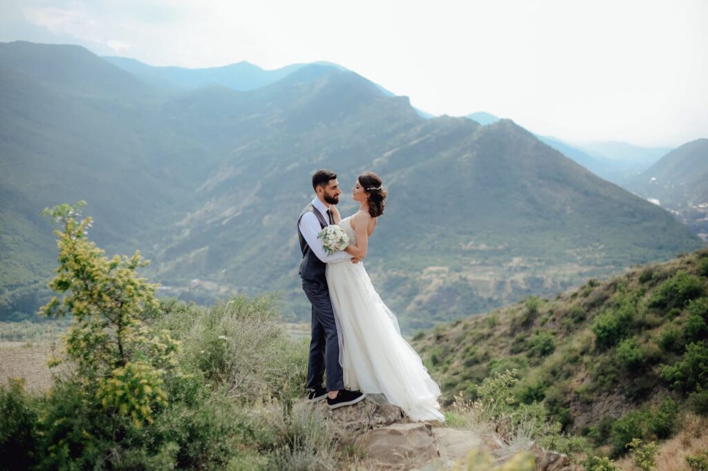 A bride and groom surrounded by mountains